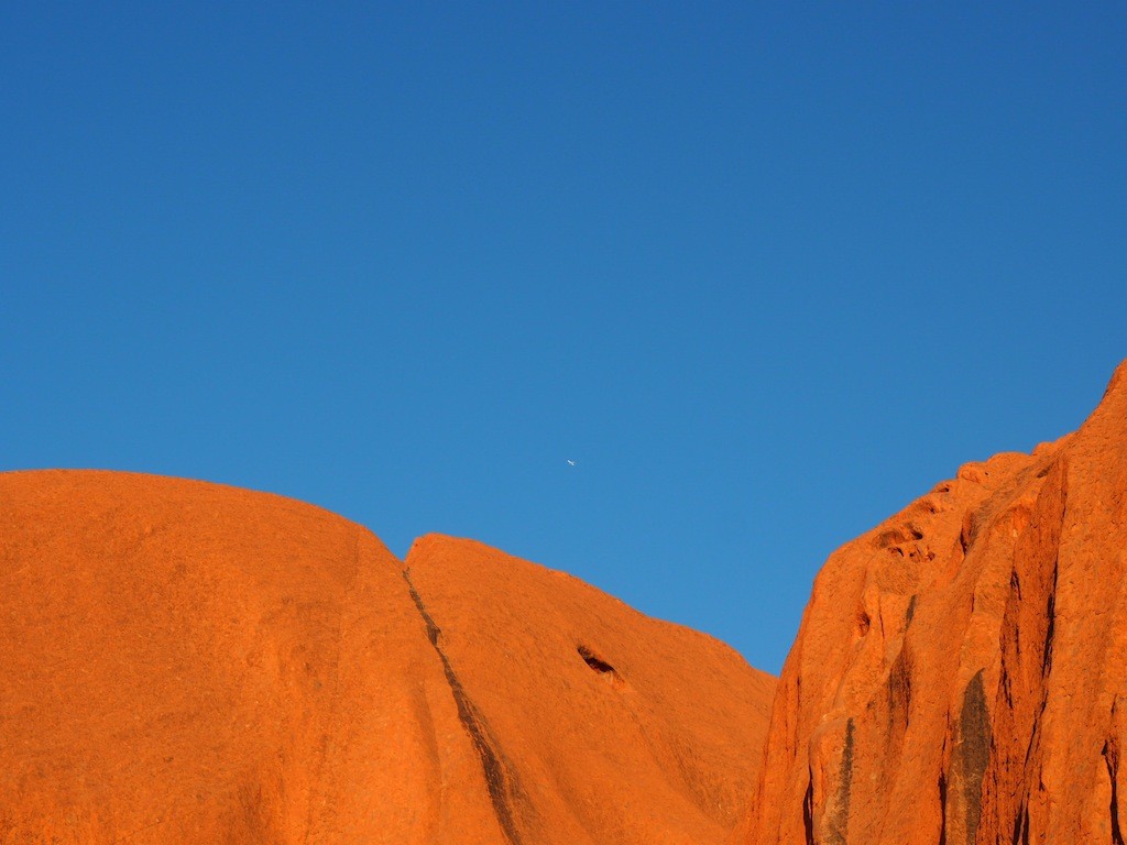 Look very closely and you'll see a plane leaving Ayers Rock airport behind Uluru